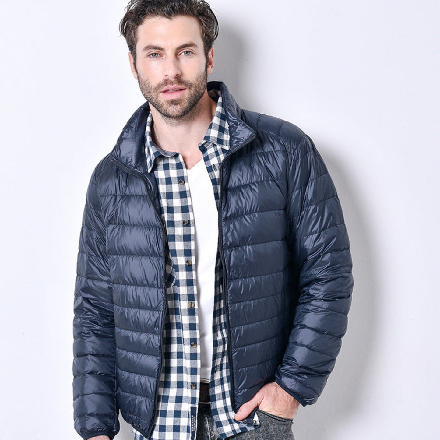 Front view of a lightweight navy blue puffer jacket with a sleek design.