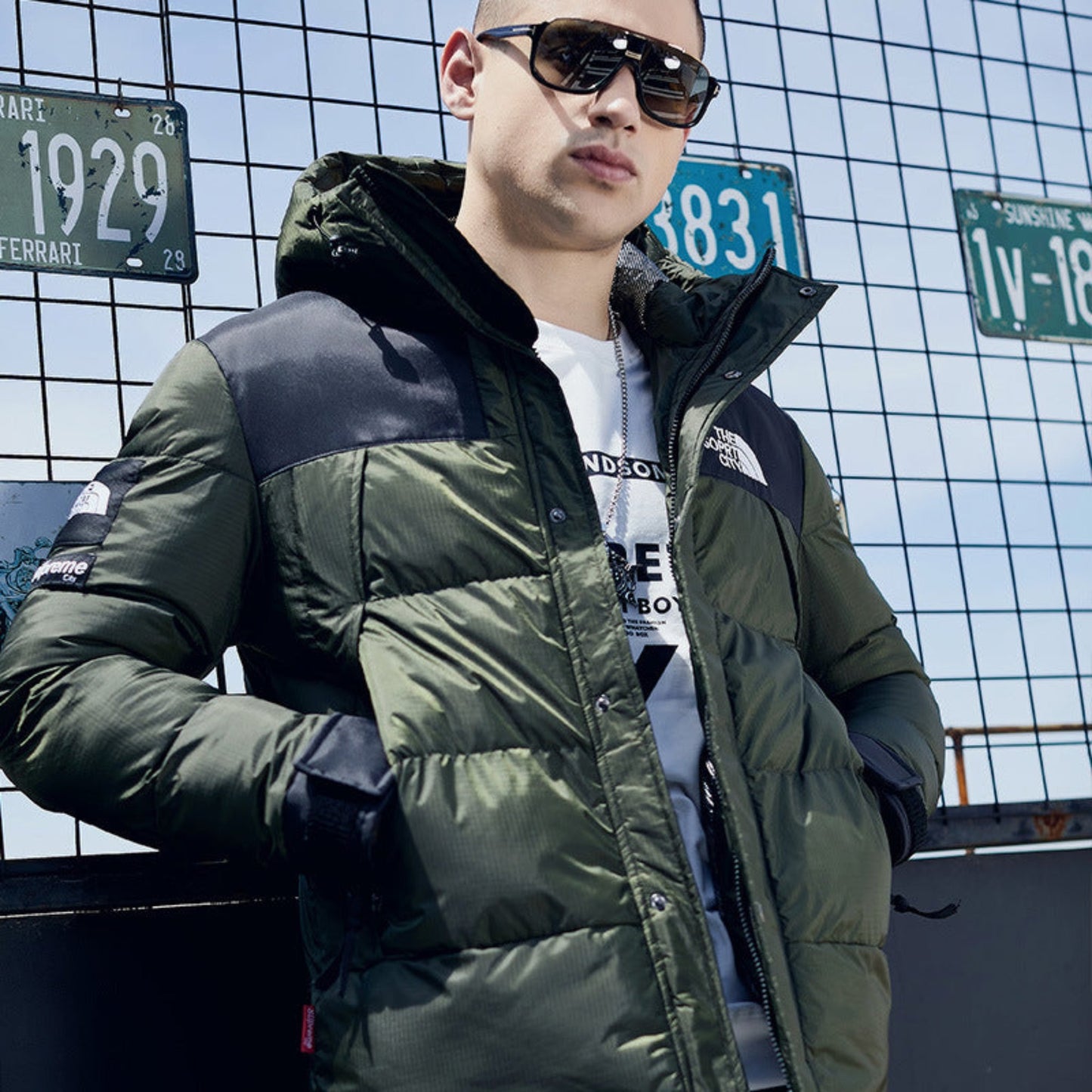 Close-up of a man showcasing the stylish details of an army green down jacket.