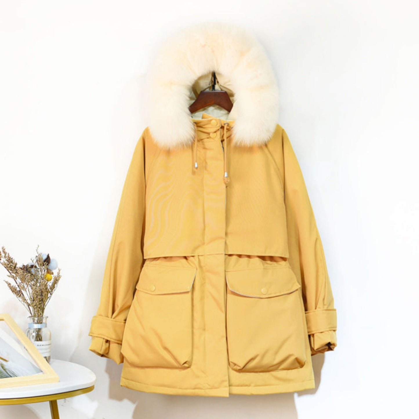 Front view of a women’s yellow fur-collar winter jacket, displayed on a mannequin, with functional zippers and cozy design.