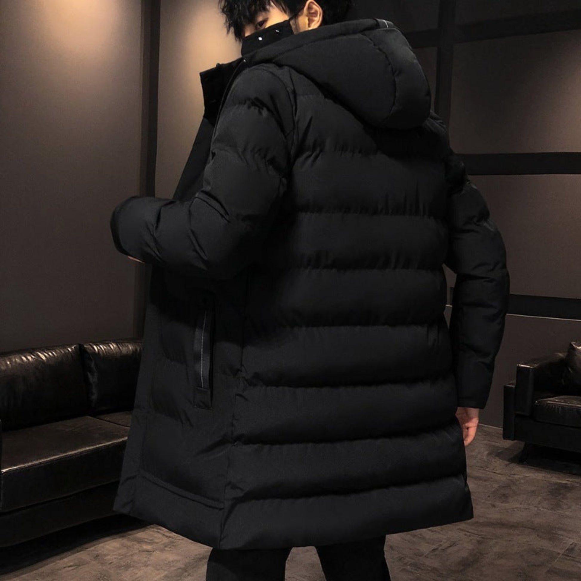 Back view of the black puffer jacket, highlighting its hood and quilted pattern in detail.