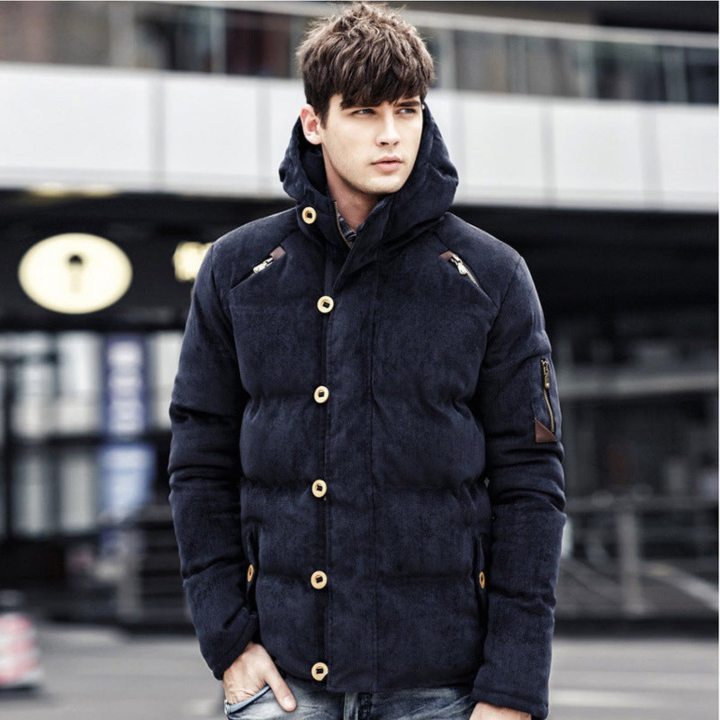 Navy blue hooded corduroy jacket worn by a model in an urban setting.