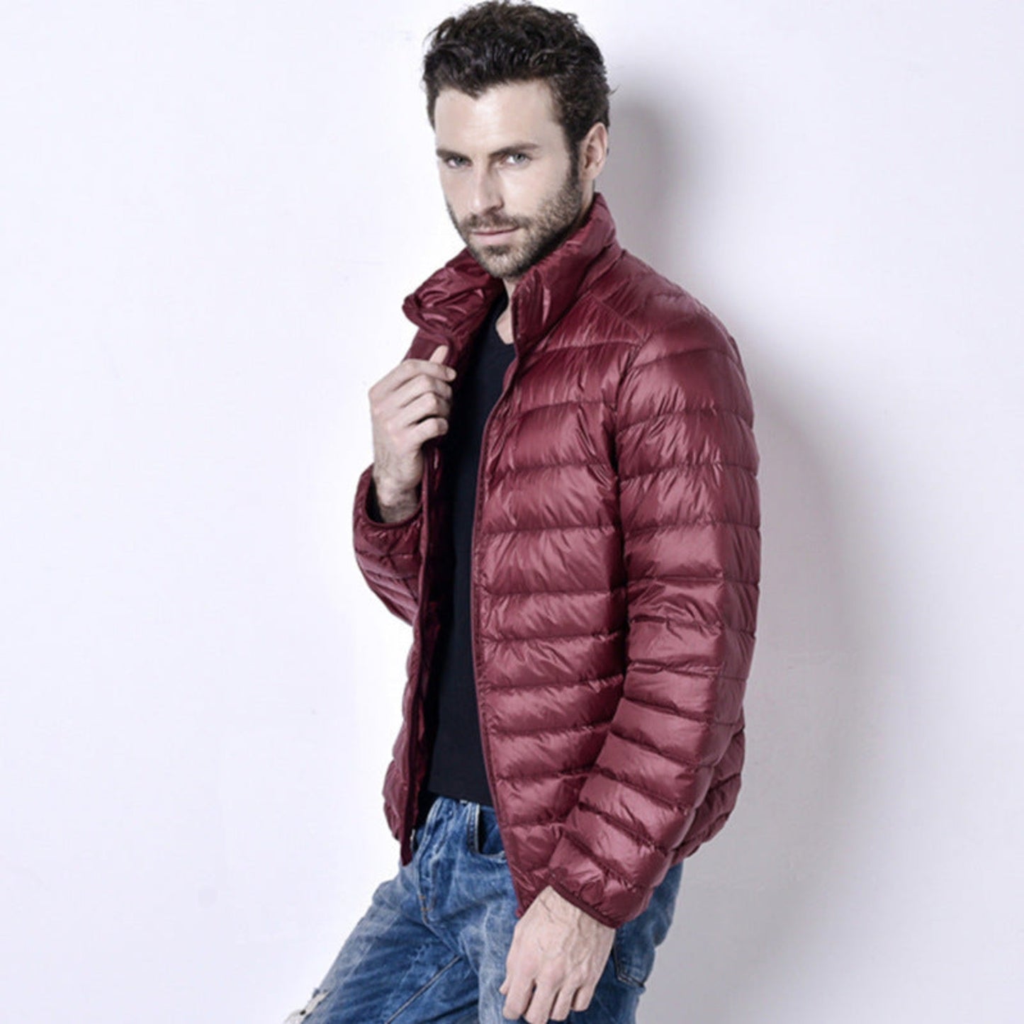 A model showcasing a lightweight burgundy puffer jacket styled with a sleek design.