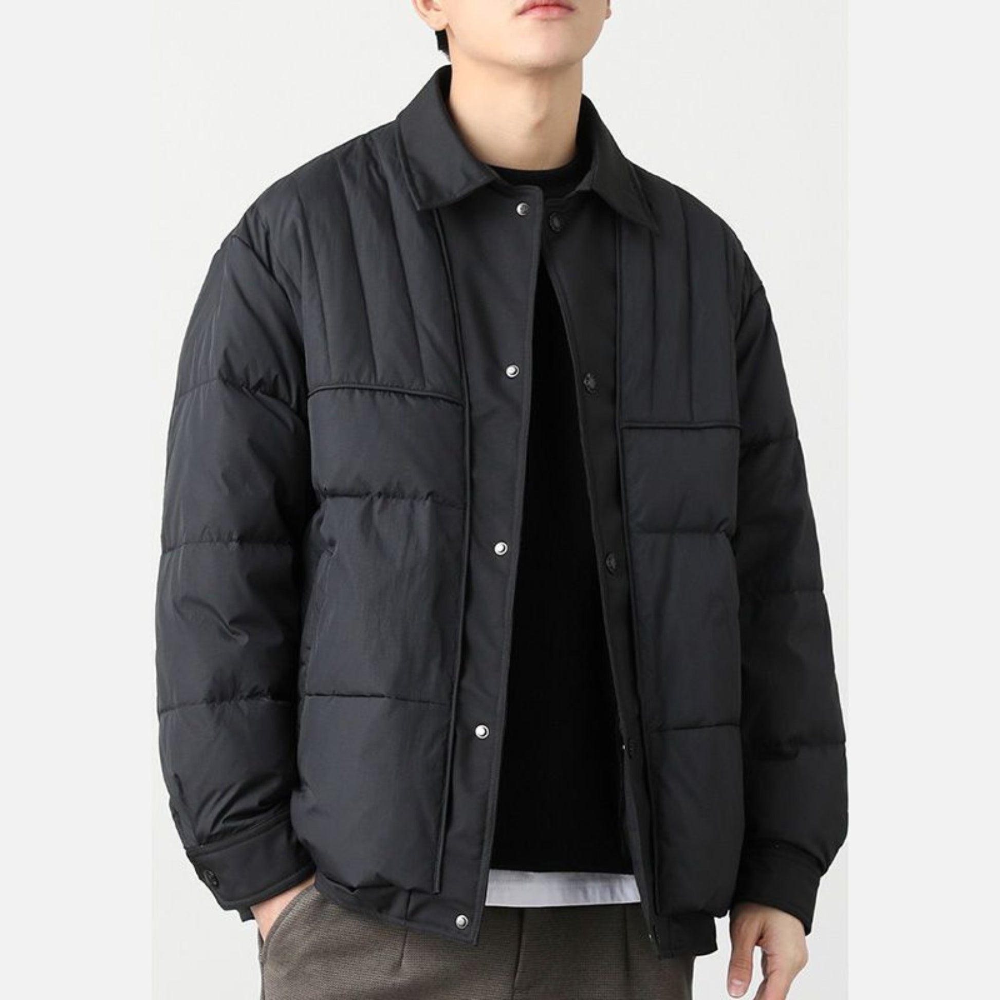 Men's black quilted jacket, angled side view showcasing casual fit and style.