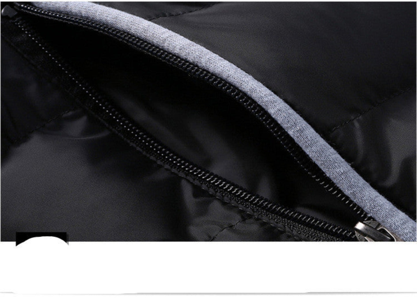 Close-up of a zippered pocket on a black winter jacket.
