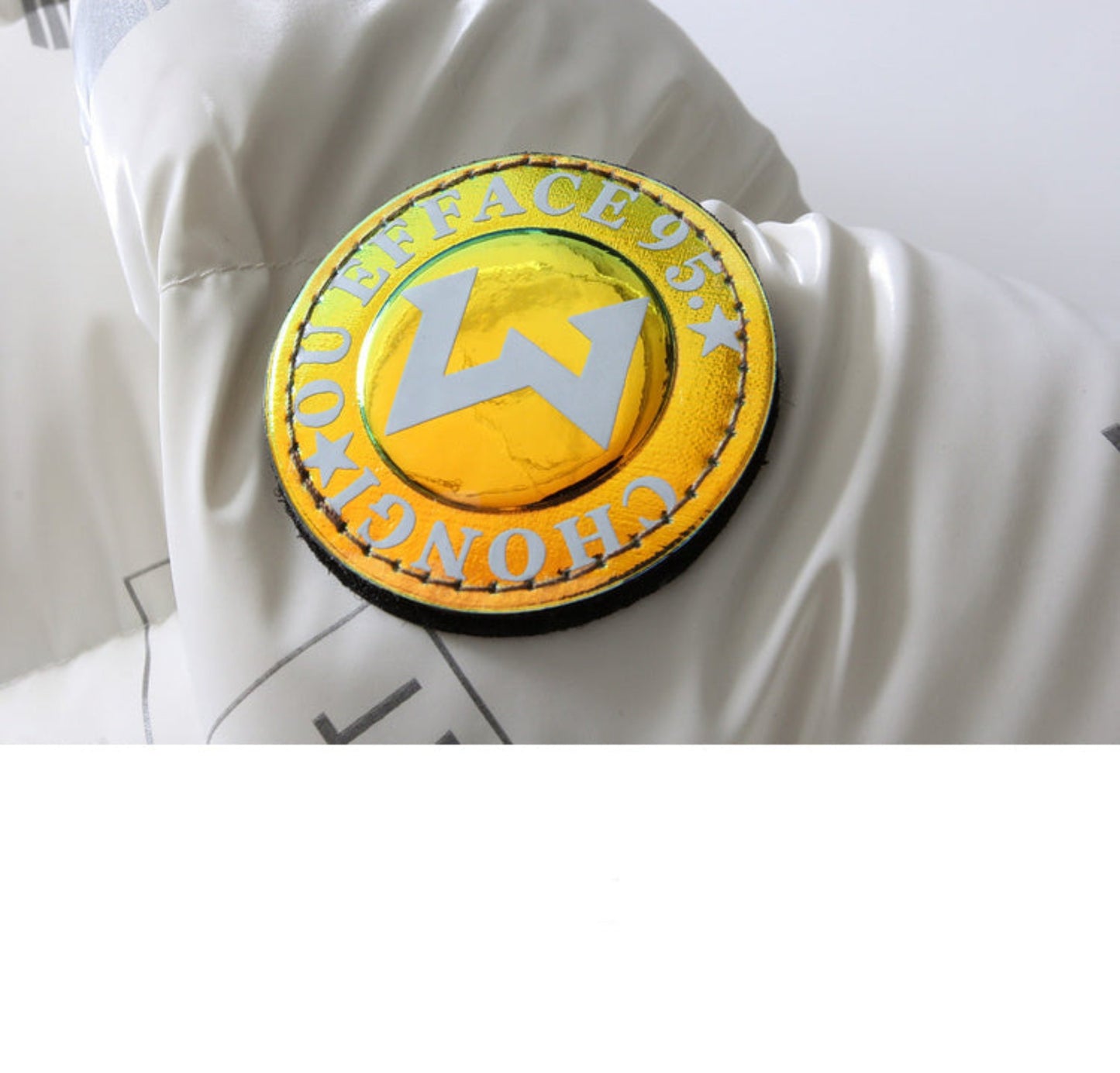 Close-up of yellow alphanumeric branding badge on duck down jacket