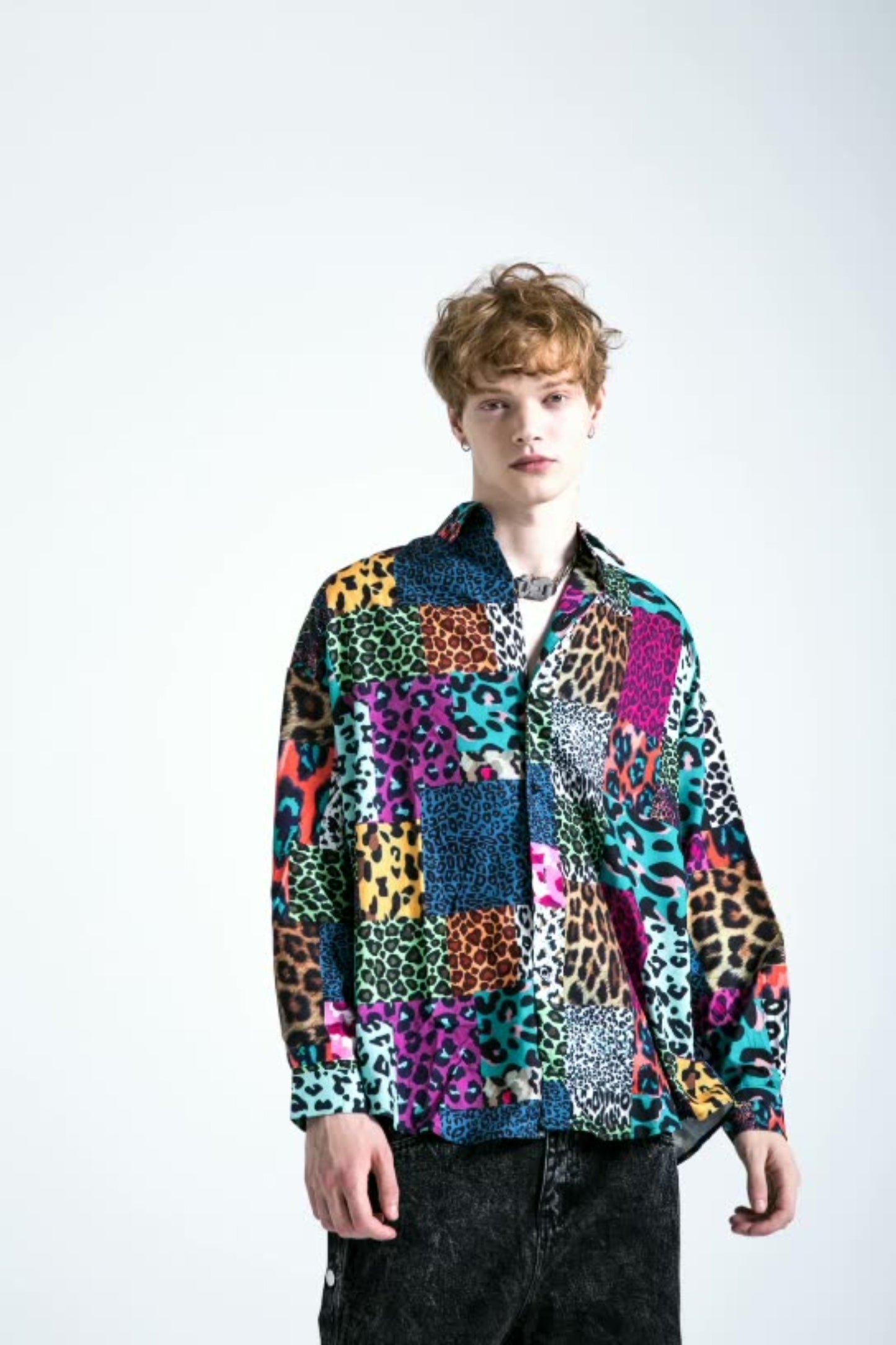 Model showcasing a men's padded winter jacket with multicolor patchwork graphic prints outdoors