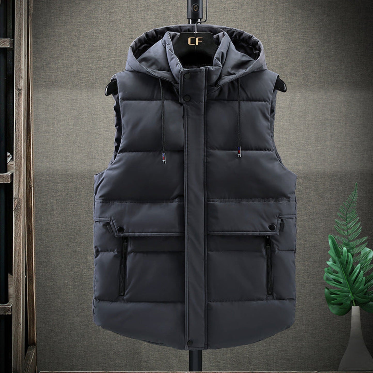 Front-facing view of grey men’s hooded down vest with functional pockets and a sleek design